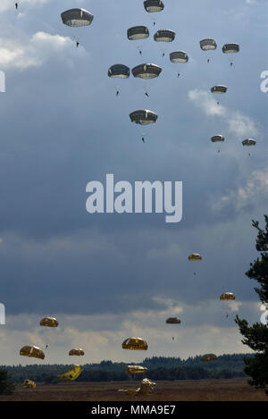 Fallschirm Vordächer füllen Sie den Himmel als Fallschirmjäger aus acht Ländern Land am Houtdorperveld Drop Zone während Falcon Sprung Sept. 15, 2017, Valkenburg, Niederlande. (U.S. Air Force Foto von Airman 1st Class Codie Collins) Stockfoto