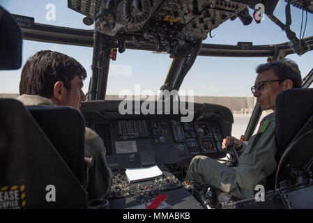 Afghanische Mi-17 Piloten sprechen über die Unterschiede zwischen einem MI-17 Helikopter und ein UH-60 Black Hawk im Cockpit des ersten Afghanischen Luftwaffe UH-60 Okt. 3, 2017, in Kandahar Airfield, Afghanistan. Die UH-60 ist ein Teil der neuen Ausbildung für die afghanischen Piloten. Die UH-60 ist die neueste Flotte hinaus für die wachsende Air Service. Mi-17 Piloten sind die ersten auf dem neuen Waffen System zu trainieren und es wird erwartet, dass sie zum Springen - Die neue Plattform in den Kampf für Afghanistan beginnen. (U.S. Air Force Foto: Staff Sgt. Alexander W. Riedel) Stockfoto