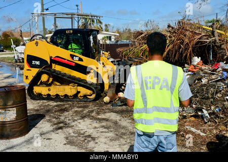 Subash Patel, eine Szene Koordinator mit der Environmental Protection Agency, leitet die Beseitigung von Fässern und Behältern durch den Hurrikan Irma in Big Pine Key, Florida, Okt. 3, 2017 verdrängt. EPA-Teams unter der Leitung von an - Szene Koordinatoren, erleichtern land-based assessments und Maßnahmen in Abstimmung mit dem Unified Command not Support Funktion 10 Florida. U.S. Coast Guard Foto von Petty Officer 2. Klasse David Weydert. Stockfoto