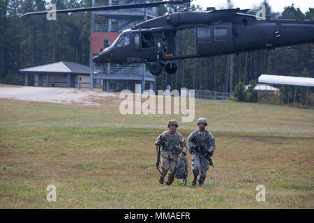 Us-Armee Sgt. 1. Klasse Christopher Taylor, Links und SPC. Isaias Santiago, rechts, U.S. Army Medical Befehl zugewiesen, verlässt ein UH-60 Blackhawk Hubschrauber auf dem Weg zu ihrem nächsten Ziel während der besten Krieger Konkurrenz am Fort A.P. Hill, Va., Nov. 5, 2017. Das BWC ist eine jährliche einwöchige Veranstaltung, die 22 Soldaten aus 11 großen Befehle auf ihre körperlichen und geistigen Fähigkeiten testen. (U.S Armee Foto von SPC. Jada Owens) Stockfoto