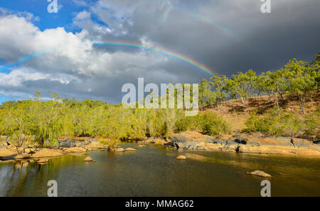 Schwarze Wolken und Regenbogen über Buschland in Palmer River Goldfield, Far North Queensland, FNQ, QLD, Australien Stockfoto