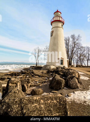 Die historische Marblehead Leuchtturm im Nordwesten von Ohio sitzt entlang der felsigen Ufer des zugefrorenen See Erie. Hier im Winter mit einem bunten Himmel gesehen. Stockfoto