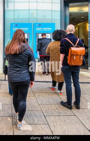London, Greenwich. Menschen Schlange an Geldautomaten Geld ziehen. TSB Bank ATM Stockfoto