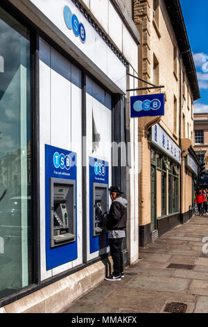 London, Greenwich. Junger Mann mit an Geldautomaten Geld ziehen. TSB Bank ATM Stockfoto