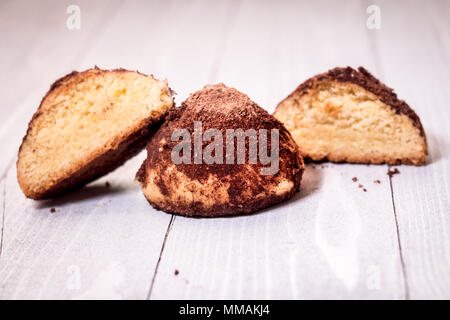 Hausgemachte Kekse mit Schokolade Trüffel auf weißem Holz mit defokussiertem Hintergrund. Stockfoto