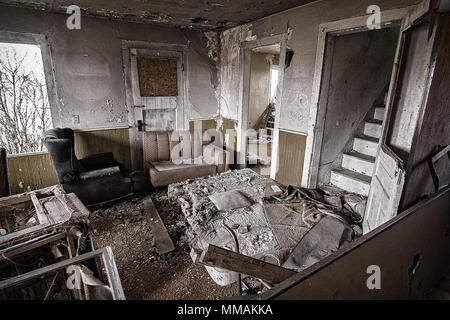 Die Innenseite eines verlassenen Hauses. Dieses Haus hat seit Jahren aufgegeben wurde und zeigt die Anzeichen von Vandalismus und der Verschlechterung. Stockfoto