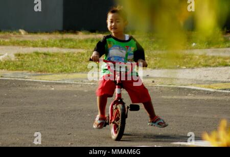 Madiun, Indonesien. 10. Mai, 2018. Kleine Kinder Erwachsene Radfahren pancal am Morgen Credit: Ajun Ally/Pacific Press/Alamy leben Nachrichten Stockfoto