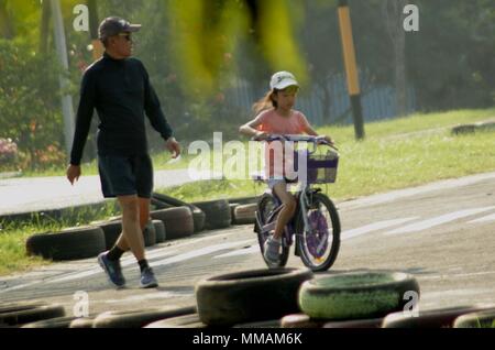 Madiun, Indonesien. 10. Mai, 2018. Kleine Kinder Erwachsene Radfahren pancal am Morgen Credit: Ajun Ally/Pacific Press/Alamy leben Nachrichten Stockfoto