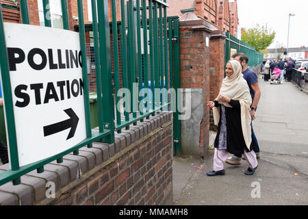 Muslimische Wähler Ankommen in einem Wahllokal in Klein Heide, Birmingham, für die Kommunalwahlen im Mai 2018. Stockfoto