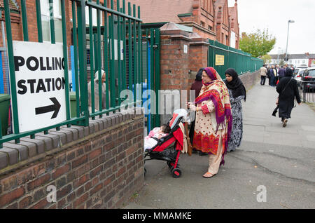 Muslimische Wähler Ankommen in einem Wahllokal in Klein Heide, Birmingham, für die Kommunalwahlen im Mai 2018. Stockfoto