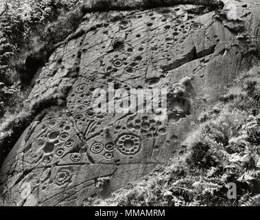 Anzeigen NW mit prähistorischen Felszeichnungen auf einem Felsvorsprung aus Schiefer (epidiorite) an Ormaig 4 km NW von Kilmartin, Argyll und Bute, Schottland, Großbritannien. Stockfoto