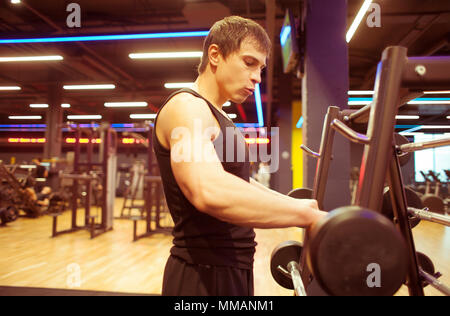 Sportler nehmen in der Nähe barbell barbell Käfig in der Turnhalle Stockfoto