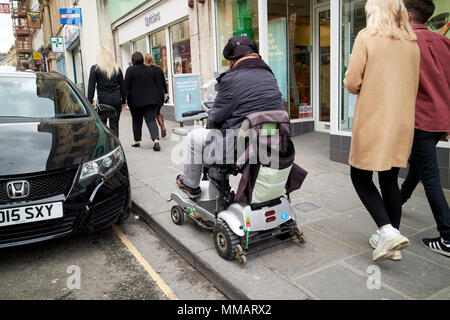 Der Mensch, er reitet Behinderung scooter von befestigten Straßen im Stadtzentrum, in der Badewanne England Großbritannien Stockfoto