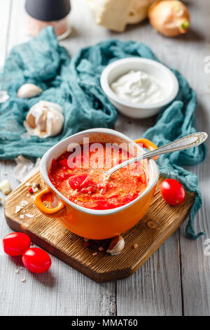 Traditionelle Suppe der Russischen und ukrainischen Küche borsch. Fleisch, Suppe mit Rüben im Orange Bowl auf einem hellen Hintergrund. Stockfoto