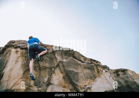 Junge Kletterer Mann an die Spitze der Mauer Stockfoto