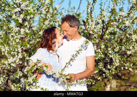 Glückliches Paar im Sommer Garten lächelnd. Stockfoto