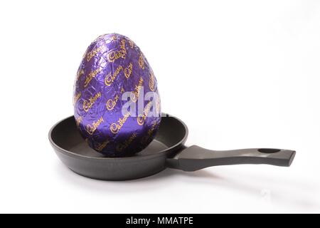 Konzept Bild eines großen Cadbury Chocolate Easter Egg in einer kleinen Pfanne auf einem weißen Hintergrund. Stockfoto