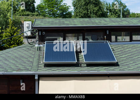 Solar Panels auf dem roten Dach auf Haus in der Natur. Close Up, alternative Energie Konzept. Stockfoto
