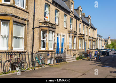 Cambridge, UK - April 2018. Die Leute von hinten zu Fuß in einer typisch britischen Straße mit klassischen englischen viktorianischen Häusern mit farbigen Türen an einem sonnigen Stockfoto