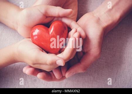 Erwachsener und Kind Hände holiding rotes Herz, Gesundheit, Liebe, spenden, Versicherungen und Familie Konzept Stockfoto