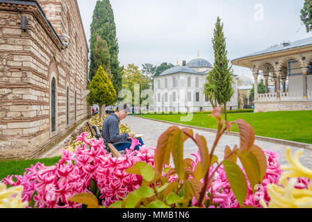 Unbekannter Mann sitzt auf Stuhl im Topkapi Palace, ein großes Museum, in Istanbul, Türkei, 11. April 2018 Stockfoto