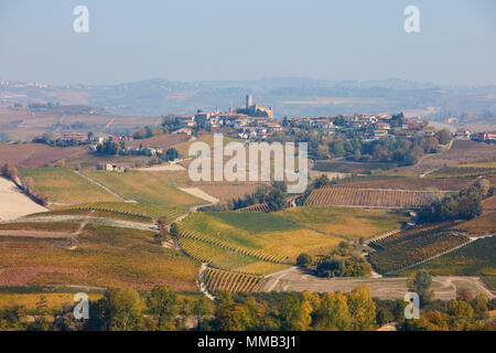 Serralunga d'Alba Stadt auf dem Hügel von Weinbergen und Feldern im Herbst umgeben, Italien Stockfoto