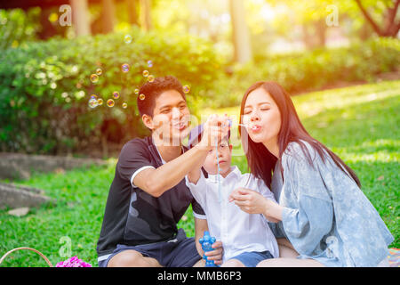 Asian teen Familie ein Kind glücklich Urlaub Picknick im Park. Spielen Bubble. Stockfoto