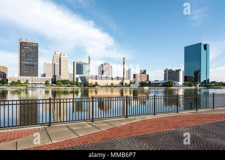 Einen Panoramablick über die Innenstadt von Toledo Ohio Skyline aus über dem Maumee River ein beliebtes Restaurant mit einem fertiger Backstein Boardwalk. Stockfoto