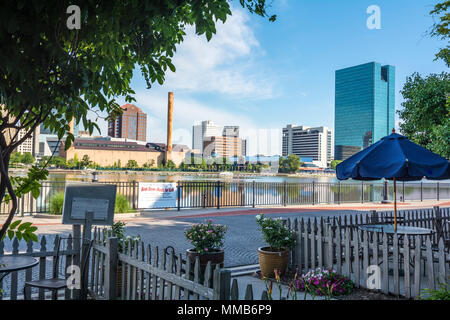 Einen Panoramablick über die Innenstadt von Toledo Ohio Skyline aus über dem Maumee River ein beliebtes Restaurant mit einem fertiger Backstein Boardwalk. Stockfoto