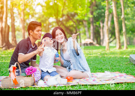 Asian teen Familie ein Kind glücklich Urlaub Picknick im Park. Spielen Bubble. Stockfoto