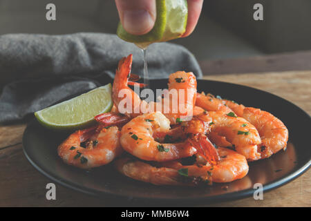 Gebraten gebratene Garnelen in der Platte mit Zitrone Grüns Petersilie Knoblauch Stockfoto