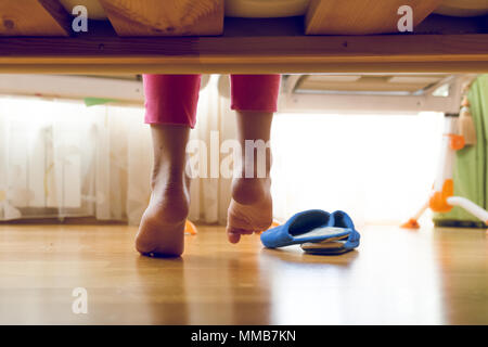 Getonten Bild unter dem Bett auf junge Mädchen im Schlafanzug für Hausschuhe suchen Stockfoto