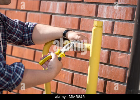 Closeup Bild der männlichen Arbeitnehmer installation Druckventil auf gelb Gasleitungen Stockfoto