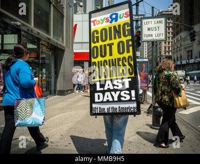 Ein Arbeiter geht Sixth Avenue in New York am Mittwoch, den 9. Mai 2018 tragen ein Schild verkündet, daß der Toys R Us Store geschlossen wird. Toys R Us ist zu liquidieren und schließen alle 735 seiner Stores in den USA. (© Richard B. Levine) Stockfoto