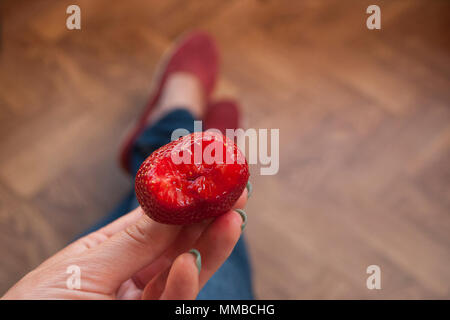 Lady's Hand mit schönen Maniküre Holding eine saftige rote Erdbeere. Stockfoto