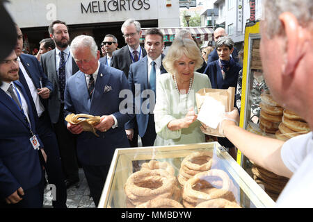 Der Prinz von Wales und die Herzogin von Cornwall versuchen koulouri, einem traditionellen griechischen Brezel, bei einem Rundgang der Kapnikarea Bereich in Athen, Griechenland, im Rahmen ihres Besuchs in dem Land. Stockfoto