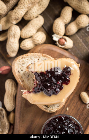 Peanut Butter und Marmelade Sandwich auf rustikalen Holzmöbeln Hintergrund. Hausgemachte gesundes Frühstück. Stockfoto