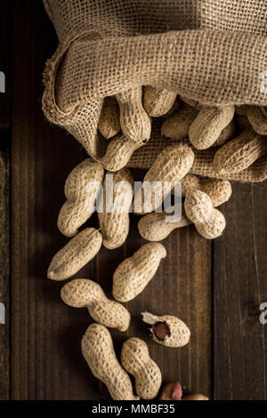 Erdnüsse in Muscheln auf Holz- Hintergrund. Im rustikalen Stil. Stockfoto