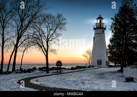 Die historische Marblehead Leuchtturm im Nordwesten von Ohio sitzt entlang der felsigen Ufer des zugefrorenen See Erie. Hier im Winter mit einem farbenfrohen Sonnenaufgang gesehen Stockfoto