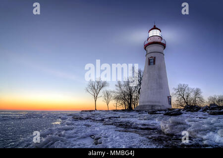 Die historische Marblehead Leuchtturm im Nordwesten von Ohio sitzt entlang der felsigen Ufer des zugefrorenen See Erie. Hier im Winter mit einem farbenfrohen Sonnenaufgang gesehen Stockfoto