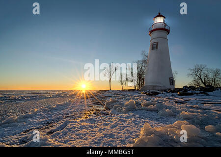 Die historische Marblehead Leuchtturm im Nordwesten von Ohio sitzt entlang der felsigen Ufer des zugefrorenen See Erie. Hier im Winter mit einem farbenfrohen Sonnenaufgang gesehen Stockfoto