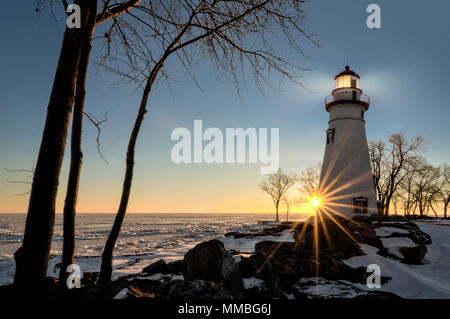 Die historische Marblehead Leuchtturm im Nordwesten von Ohio sitzt entlang der felsigen Ufer des zugefrorenen See Erie. Hier im Winter mit einem farbenfrohen Sonnenaufgang gesehen Stockfoto