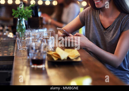 Mittelteil der Frau sms in Restaurant Stockfoto