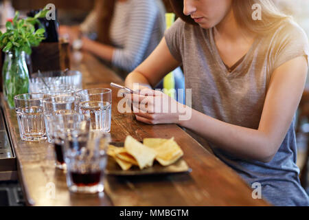 Mittelteil der Frau sms in Restaurant Stockfoto