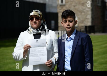 Fatima Boudchar (links) und ihrem Sohn Abderrahim Belhaj, 14, halten eine Entschuldigung schreiben außerhalb der Häuser des Parlaments in London. Die britische Regierung hat a&Ograve; volle und endgültige Regelung&Oacute; ehemalige libysche dissident Abdul Hakim Belhaj, Attorney General Jeremy Wright hat das Unterhaus gesagt. Stockfoto