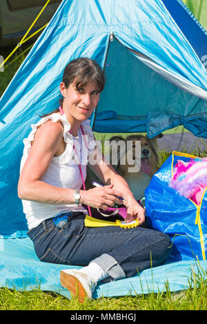 Frau sitzt außerhalb Zelt mit Rough collie Hund innen im Hampshire Spiel & Country Fair, netley Marsh, Hampshire Großbritannien im Mai Stockfoto