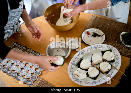 Hohen winkel Nahaufnahme von zwei Frauen an einem Tisch stehend, die Vorbereitung der Platte von Sushi. Stockfoto