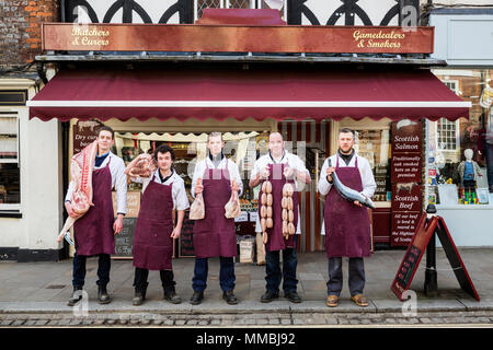 Gruppe von Männern, Metzger, Fischhändler, Schürzen tragen, stehend auf dem Bürgersteig außerhalb einer Metzgerei, Fleisch und Fisch, auf der Suche ca Stockfoto