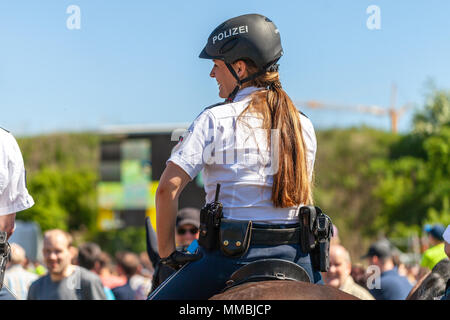 DELMENHORST/Deutschland - Mai 6, 2018: Die Deutsche Polizei Reiterin reitet auf einem Pferd für Training in einer Masse. Das deutsche Wort Polizei bedeutet Stockfoto