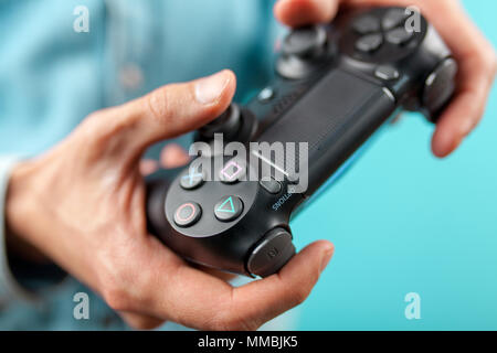 Männliche Hände halten ein PS4-Controller Stockfoto